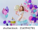 Small photo of Unicorn Girl holding gold confetti air baloon. Idea for decorating unicorn style birthday party. Unicorn decoration for festival party girl.