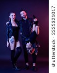 Full length photo of stylish funny family mom dad with baby girl where dad holds daughter upside down on dark background. Family look