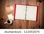 Workspace with coffee cup, instant photos, note paper and notebook on old wooden table