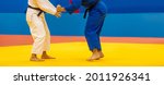 Small photo of Two judo fighters in white and blue uniform. Horizontal sport poster, greeting cards, headers, website