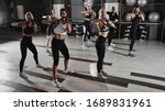 Women in black and white sportswear on a real group body Combat workout in the gym train to fight, kickboxing with a trainer