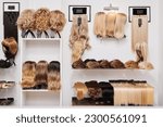 Small photo of Showcase of natural looking wigs in different colors fixed on the metal wig holders in beauty salon. Row of mannequin heads with variation shades hair on shelf in wig shop