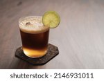 Espresso tonic in simple glass on walnut wood table with copy space , shallow focus