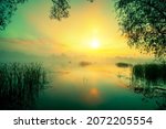 Magic sunrise over lake. Misty early morning, rural landscape, wilderness, mystical feeling. Serenity lake in magical light