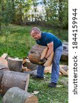 Small photo of Strong lumberjack manhandling the logs