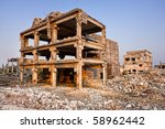 Small photo of Landscape of ruined buildings at sunset, image of decrepitude or natural disaster