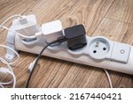 Smartphone, mobile phone chargers connected to electrical power strip. Various devices charging concept