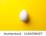 white egg on a yellow... | Shutterstock . vector #1104258437