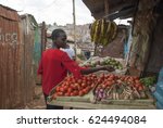 Small photo of NAIROBI, KENYA - FEBRUARY 29: Unidentified woman buys vegetables in a street shop of Kibera, Nairobi, Kenya, February 29, 2012. Kibera is the biggest slum in Africa with insanitary living conditions.