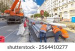 Installing concrete plates by crane at road construction site timelapse hyperlapse. Industrial workers with hardhats and uniform. Reconstruction of tram tracks in the city street