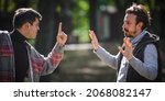 Small photo of Close-up finger pointing of two very angry, nervous and upset men in an aggressive and fierce quarrel conflict on the verge of a physical confrontation and a fight. Concept of male conflict