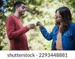 Small photo of Cheers. Very drunk couple, a boy and a girl, chug shot drink from small glasses. Express drinking and fast get drunk concept