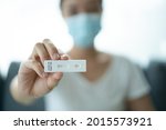 Asian young woman with hygiene protective face mask using SARS 2019-nCoV COVID-19 coronavirus antigen rapid test kit - ag test kit at home. COVID-19 antigen rapid test.