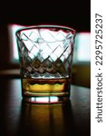 Small photo of Half empty glass of whiskey drink with chromatic aberrations