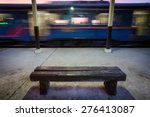 Bench on the platform with moving fast train