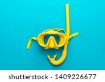 flat lay shot of yellow diving mask with snorkel over turquoise blue background. minimalist photo of dive mask and snorkel with central composition