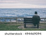 Man sitting on bench overlooking sea