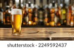 Small photo of Glass of chilled beer on table and blurred sparkling bar background.