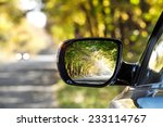 Reflection of  sunny autumn road at the car side mirrow.