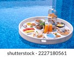 Breakfast in swimming pool, floating breakfast in villa resort. relaxing in calm pool water, healthy breakfast and tropical fruit.