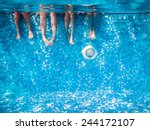 Children's and adults legs underwater in the swimming pool