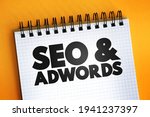 Seo and Adwords text on notepad, business concept background