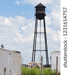 Small photo of Dougherty, Texas / USA - July 26 2010: Tin Man Style Water Tower painted black near the town center.