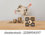 Small photo of For buyer or customer persona behavior, journey exploratory and analysis. Customer research concept. Who, what, how, why text on wooden cube block with blurred credit card in shopping cart and coins
