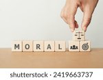 Small photo of For business ethics and compliance concept. Ethical investment, sustainable development. Business integrity and moral. Hand arrange wooden cube block with MORAL text including copy space