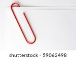 Red paper clip attached to multiple sheets of paper.