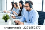 Small photo of Call center operator agents in headset communicating with clients at online support service office. Serious man wearing hands-free headset using laptop.