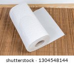 Small photo of Roll of two-ply paper towels with tear-off sheets on the wooden bamboo table mat