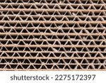 Small photo of Top view of the cross section of the multilayer glued unbleached light brown corrugated cardboard close-up, texture, background