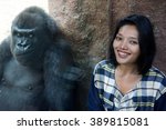 Small photo of Zoo visitor at the gorilla enclosure. Cheerful girl next to the monkey cage.