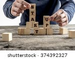 Front view of a businessman arranging wooden cubes in a structure reading Start up. Conceptual of business startup and strategy.