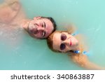 A man and woman float in blue lagoon spa resort in Iceland, their heads are in front each other