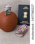 Small photo of Indian Passport and Kids piggy bank or coin stack jar for money savings cash deposit for future. Success and profit from business. new currency bank note Rs. 2000, 500 of India for making world tour.