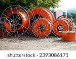 Various rolls of orange fiber optic cable for faster internet in rural areas. As underground cable for laying in the ground. Bad Munder Beber, Lower Saxony, Germany.                      