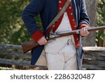 Small photo of musket on hands of American Revolution british soldier settler in Yorktown, Virginia USA