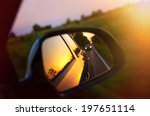 Driving at sunset - peek into a rear view mirror
