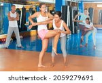 Young woman training knee strike during self protection class.