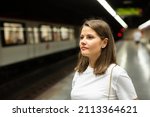 Young woman waiting train in platform of underground station