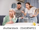 Small photo of Chagrined senior woman having problems in relationship with young couple