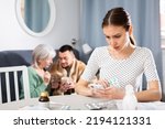 Small photo of Young wife carefully reads the annotation for medicines and checks the information on the Internet