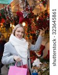 Small photo of Yappy blonde girl shopping at festive fair before Xmas