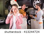 Small photo of Unhappy female client duping by troubleshooters at auto service