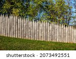 Stockade fence, sharpened and pointed tree trunks