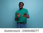 Small photo of dissatisfied squeamish young brunette african man with dreadlocks in t-shirt