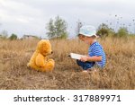 Cute girl reading book Teddy bear on the grass.