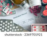 Small photo of A patient's daily routine managing multiple medications. The central focus is on a medication schedule chart surrounded by an array of different medicines. Selective focus.